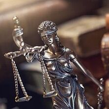 Justitia-Figur vor Büchern