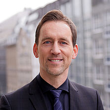 DRB-Bundesgeschäftsführer Sven Rebehn mit Häuser im Hintergrund
